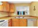 Galley kitchen features wood cabinets, ample countertop space, and a pass-through to the living area at 9231 Ventana Ln, Orlando, FL 32825