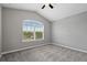 Cozy bedroom with a large arched window, vaulted ceiling, and neutral walls and carpet at 9478 Silver Buttonwood St, Orlando, FL 32832