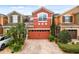 Charming townhome featuring a two-car garage, lush landscaping, and a brick-paved driveway at 9478 Silver Buttonwood St, Orlando, FL 32832
