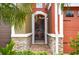 Inviting arched doorway with decorative stone accents and a gated entry for added security at 9478 Silver Buttonwood St, Orlando, FL 32832