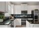 Modern kitchen with white cabinets, stainless steel appliances, and dark backsplash at 9478 Silver Buttonwood St, Orlando, FL 32832