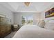 Bedroom featuring a large window, ceiling fan, dresser and gray chair at 9478 Silver Buttonwood St, Orlando, FL 32832