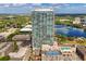 Stunning aerial view of a modern high-rise building with a pool and lake backdrop at 150 E Robinson St # 2506, Orlando, FL 32801