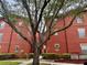 Red brick apartment building featuring mature trees and well-maintained grounds at 107 Vista Verdi Cir # 121, Lake Mary, FL 32746