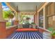 Inviting front porch featuring a comfortable porch swing with decorative pillows and blue-striped rug at 117 N Thornton Ave, Orlando, FL 32801