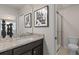 Tastefully designed bathroom with granite counters, dark cabinets, glass shower and modern artwork at 15980 Cape Coral Loop, Clermont, FL 34714