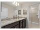 Bathroom featuring a double vanity with granite countertops and a glass-enclosed shower at 15980 Cape Coral Loop, Clermont, FL 34714