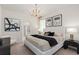 This bedroom features an elegant chandelier, neutral walls, and a cozy bed at 15980 Cape Coral Loop, Clermont, FL 34714