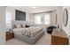 Stylish bedroom with a gray upholstered bed, modern art, sheer curtains, and neutral carpet at 15980 Cape Coral Loop, Clermont, FL 34714