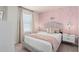 Serene bedroom featuring a pink accent wall, stylish decor, and two nightstands at 15980 Cape Coral Loop, Clermont, FL 34714