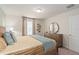 Comfortable bedroom featuring a plush bed, dresser with mirror, and warm, neutral decor at 15980 Cape Coral Loop, Clermont, FL 34714