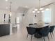 Elegant dining area featuring modern lighting, comfortable seating, and an open layout connecting to the kitchen at 15980 Cape Coral Loop, Clermont, FL 34714