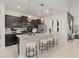 Modern kitchen featuring granite countertops, pendant lighting, stainless steel appliances and breakfast bar seating at 15980 Cape Coral Loop, Clermont, FL 34714
