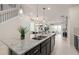 Spacious kitchen showcasing granite countertops, stainless steel appliances and breakfast bar seating that opens to dining area at 15980 Cape Coral Loop, Clermont, FL 34714