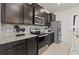 Well-equipped kitchen with stainless steel appliances, granite countertops, tile backsplash and dark cabinetry at 15980 Cape Coral Loop, Clermont, FL 34714