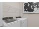 Laundry room with modern appliances, white shelving, and neutral decor at 15980 Cape Coral Loop, Clermont, FL 34714