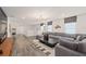This living room has an oversized gray sectional, movie art, and hardwood floors at 15980 Cape Coral Loop, Clermont, FL 34714