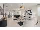 Open-concept living space with contemporary furnishings, black and white art, and a view of dining area at 15980 Cape Coral Loop, Clermont, FL 34714