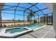Screened-in pool and spa with a view of the green space and adjacent property, perfect for outdoor living at 15980 Cape Coral Loop, Clermont, FL 34714