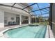 Inviting pool and spa surrounded by a screened enclosure, featuring an outdoor kitchen and lounge area at 15980 Cape Coral Loop, Clermont, FL 34714
