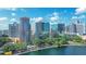 Aerial view of modern buildings, blue lake, and city skyline with trees for a serene and scenic view at 322 E Central Blvd # 1008, Orlando, FL 32801