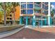 Inviting condo exterior featuring colorful architecture, lush palm trees, and a serene water fountain at 322 E Central Blvd # 1008, Orlando, FL 32801