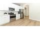 Modern kitchen with white cabinets, stainless steel appliances and wood floors at 3835 Rock Hill Loop, Apopka, FL 32712