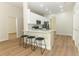 Kitchen with white cabinets, stainless appliances, counter seating and wood floors at 3835 Rock Hill Loop, Apopka, FL 32712