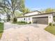 Contemporary home with a paved driveway, two-car garage, and well-maintained landscaping at 702 S Lake Adair Blvd, Orlando, FL 32804