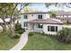 Charming two-story home featuring lush landscaping, light blue shutters, and a welcoming tile roof at 702 S Lake Adair Blvd, Orlando, FL 32804