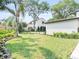 Charming front yard featuring a well-manicured lawn, flower beds, and a white home at 702 S Lake Adair Blvd, Orlando, FL 32804