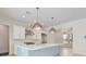 Modern kitchen features white cabinetry, a blue island, stainless steel appliances, and stylish pendant lighting at 702 S Lake Adair Blvd, Orlando, FL 32804