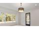 Bright living room featuring large windows, hardwood floors, and stylish light fixture at 702 S Lake Adair Blvd, Orlando, FL 32804