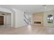 Spacious living room featuring a stone fireplace, staircase and stylish light fixture, with hardwood floors at 702 S Lake Adair Blvd, Orlando, FL 32804