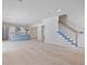 Open-concept living room and kitchen area with light wood floors and a staircase, perfect for entertaining at 702 S Lake Adair Blvd, Orlando, FL 32804