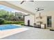 Covered patio with a full outdoor kitchen, ceiling fans, and views of the backyard pool at 702 S Lake Adair Blvd, Orlando, FL 32804