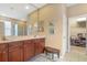 Well-lit bathroom with dual sinks, granite countertops, and a walk-in closet at 9244 Pecky Cypress Way, Orlando, FL 32836