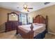 Spacious bedroom featuring a ceiling fan, carpet, and dresser with a large carved mirror at 9244 Pecky Cypress Way, Orlando, FL 32836