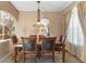 Elegant dining room with a glass-top table, upholstered chairs, and arched doorways at 9244 Pecky Cypress Way, Orlando, FL 32836