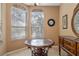 Dining room features two large windows with ornate trim and a round table with a marble top at 9244 Pecky Cypress Way, Orlando, FL 32836