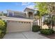 Charming two-story home with a beige exterior, attached two-car garage, and manicured landscaping at 9244 Pecky Cypress Way, Orlando, FL 32836