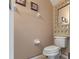 Neutral half-bathroom featuring a standard toilet, vanity mirror, and framed artwork at 9244 Pecky Cypress Way, Orlando, FL 32836
