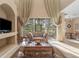Living room with neutral decor features tile flooring, large windows, and elegant curtains at 9244 Pecky Cypress Way, Orlando, FL 32836