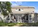 Rear view of the home with a screened-in patio and a well-maintained lawn at 9244 Pecky Cypress Way, Orlando, FL 32836