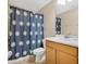 Well-lit bathroom features a vanity with cabinets and a shower with decorative curtain at 987 Alston Bay Blvd, Apopka, FL 32703