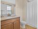 This bathroom features a wood vanity, toilet and a shower with a white curtain at 987 Alston Bay Blvd, Apopka, FL 32703