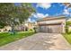 A home featuring a large driveway leading to a garage, along with a well-manicured lawn at 987 Alston Bay Blvd, Apopka, FL 32703