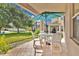 Covered patio with a table and chairs, ideal for outdoor dining and relaxation with a view of the lush backyard at 987 Alston Bay Blvd, Apopka, FL 32703