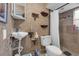 Small bathroom featuring unique textured walls, toilet, sink, cabinet, and shelving with shower at 1000 E Anderson St, Orlando, FL 32801