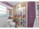 Cozy bathroom featuring tile flooring, window, toilet, and shower with patterned curtain and light fixture at 1000 E Anderson St, Orlando, FL 32801